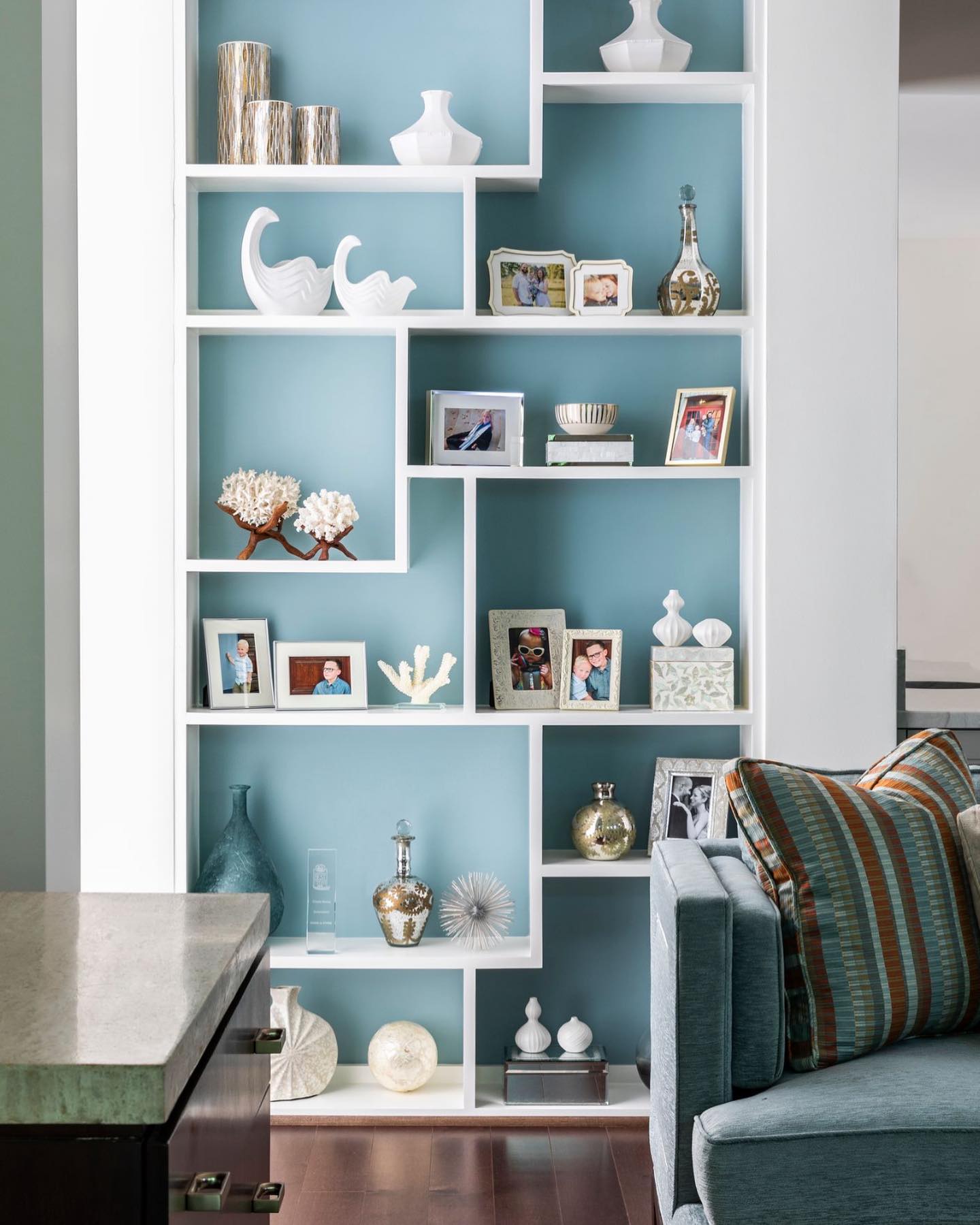 Achieve a nautical feel by painting your walls and shelves white and adding ocean blue paint to the back of your shelves. Use of ocean blue paint in the back of bookshelves framed in white